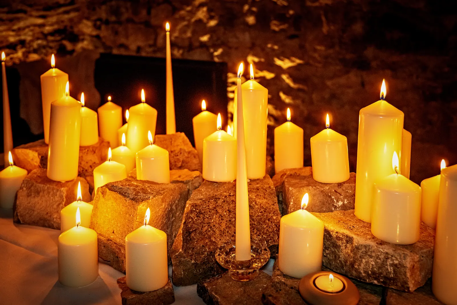 Bougies allumées posées sur la pierre, lueur dorée