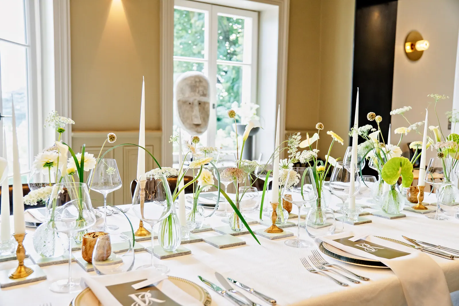 Table dressée devant les grandes fenêtres lumineuses du château