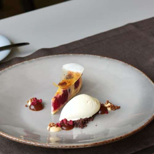 Tarte façon clafoutis aux cerises servie avec une glace vanille, émietté de biscuit chocolat, coulis et éclats de fruits rouges