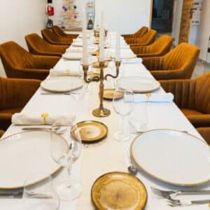 Table élégante dressée pour un dîner gastronomique privé avec vaisselle raffinée, chandeliers et chaises confortables.