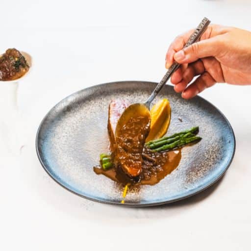 Magret de canard nappé d'une sauce volaille à la prune, accompagné d’asperges vertes, purée de patate douce, et œufs de canard en persillade.