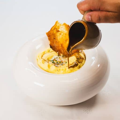 Espuma de maïs avec œuf parfait, chips de poulet et jus de volaille