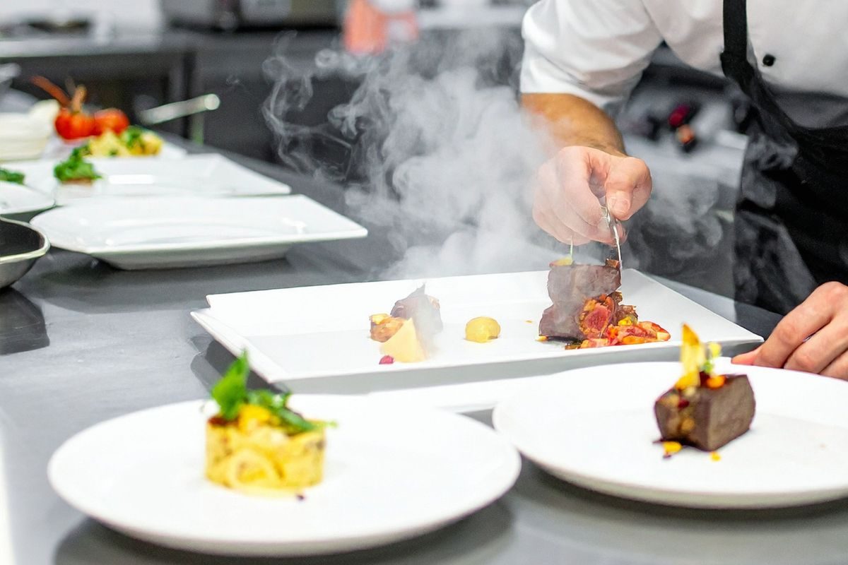 Chef à domicile préparant un repas gastronomique chez un particulier